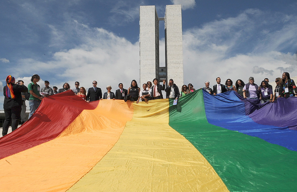 Grupo de pessoas segurando a bandeira LGBT em frente ao Congresso Nacional. Grupo de pessoas segurando a bandeira LGBT em frente ao Congresso Nacional.