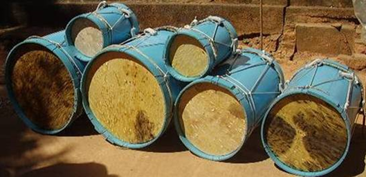 Fotografia de seis tambores nas cores azul e bege empilhados. Fotografia de seis tambores nas cores azul e bege empilhados.