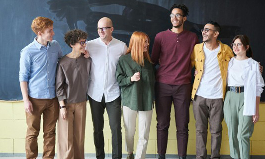 Fotografia de um grupo com cinco homens e duas mulheres de pé em frente a uma lousa. Fotografia de um grupo com cinco homens e duas mulheres de pé em frente a uma lousa.