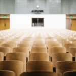 Fotografia de cadeiras de madeira vazias em um auditório